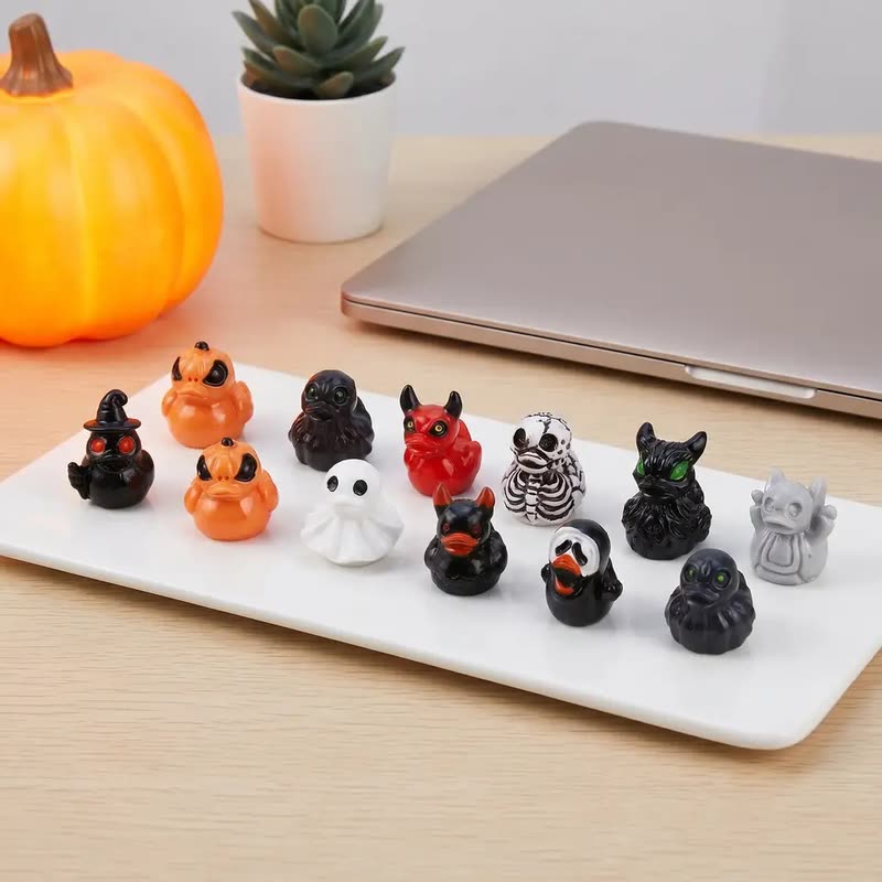 Mini resin duck figurines dressed up as ghosts, pumpkins, skeletons and bats on a white tray (seller photo from the AliExpress listing)