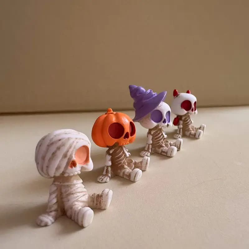 Four mini resin skeleton figurines: a mummy, a pumpkin head, one in a purple witch hat and a red skull (seller photo from the AliExpress listing)