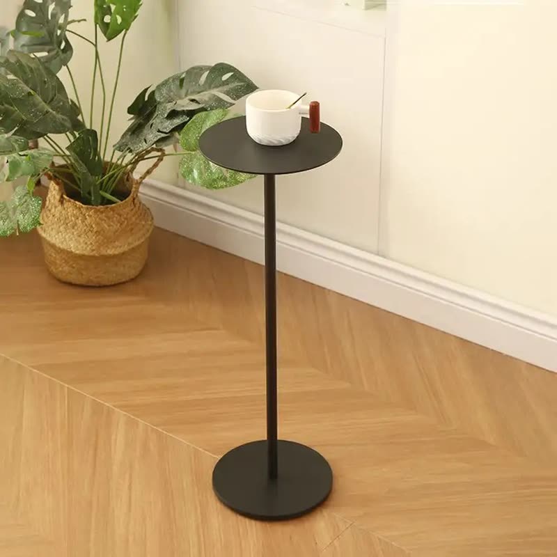 Slim black round metal side table holding a mug next to a potted plant in a woven basket (seller photo from the AliExpress listing)