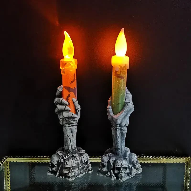 Two flameless LED taper candles held upright by grey skeleton-hand holders (seller photo from the AliExpress listing)
